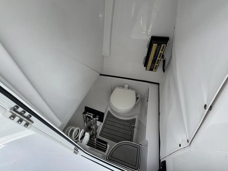Slide: The Image of 2025 Sportsman Heritage 261 boat interior with compact marine toilet and storage. - 19