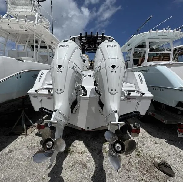 Slide: The Image of 2025 Sportsman Heritage 261 boat with dual outboard engines, parked on a sunny day. - 3
