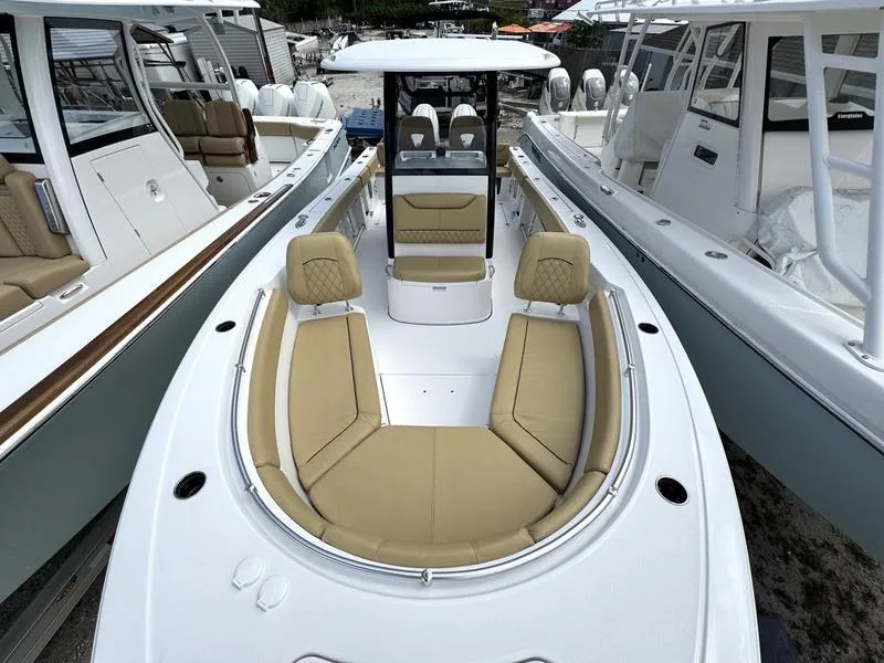 Slide: The Image of 2025 Sportsman Heritage 261 boat with tan seating, docked among other boats. - 6