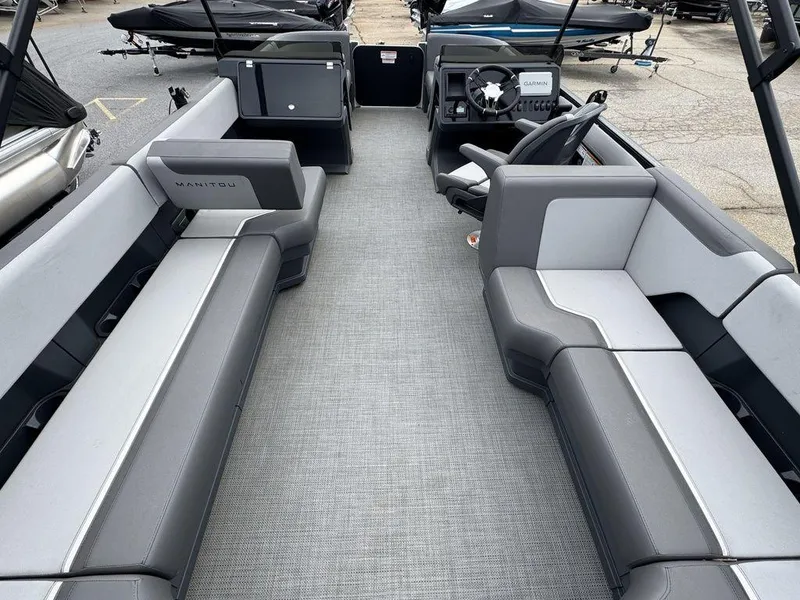 Slide: The Image of 2024 Manitou Cruise 22 Switchback pontoon boat interior with gray seating and steering console. - 13