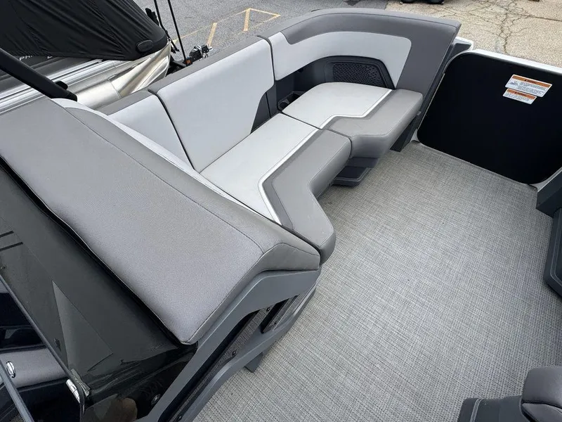 Slide: The Image of 2024 Manitou Cruise 22 Switchback boat interior with gray seating and carpeted flooring. - 14