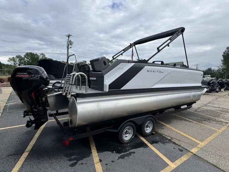 Slide: The Image of 2024 Manitou Cruise 22 Switchback pontoon boat on trailer, featuring sleek design and powerful engine. - 3