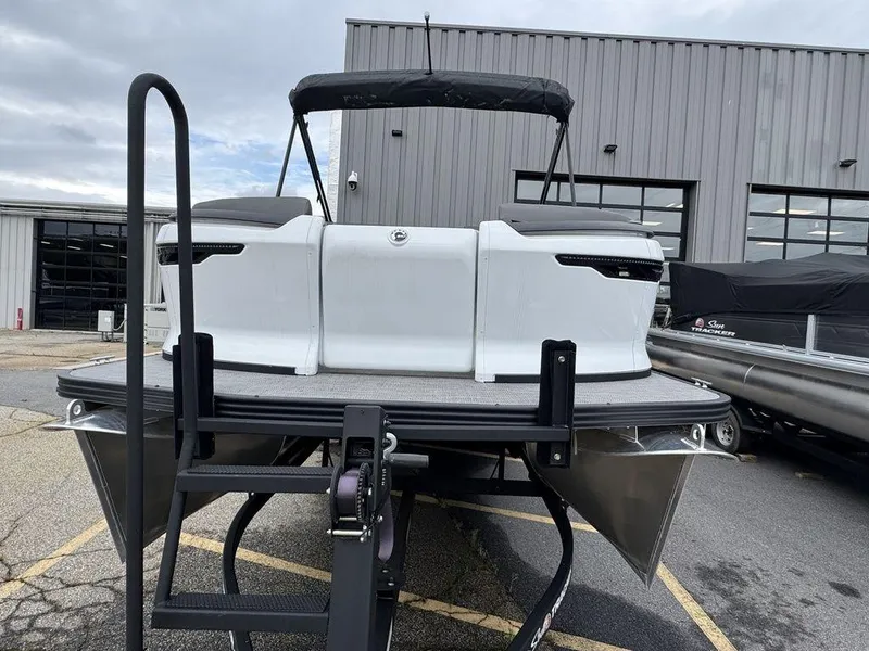 Slide: The Image of 2024 Manitou Cruise 22 Switchback pontoon boat with canopy, docked outdoors. - 5