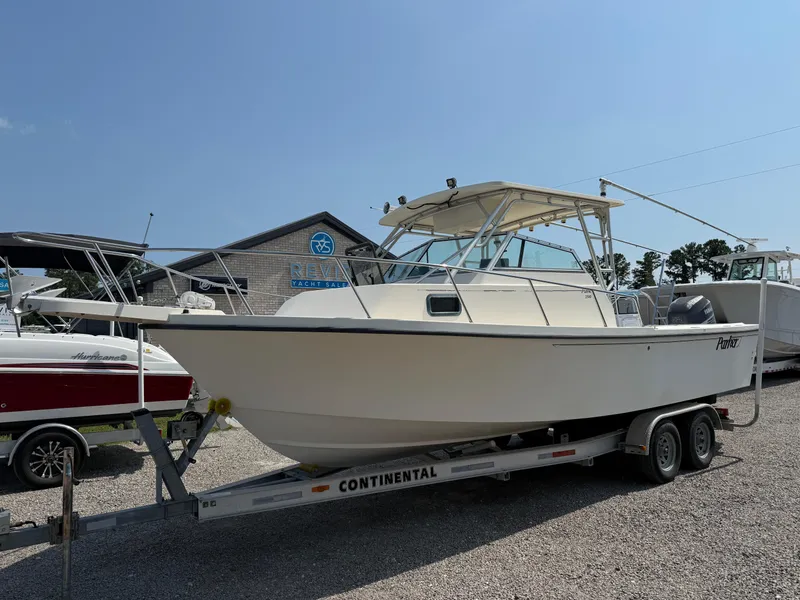 The Image of 2004 Parker 2510 Walkaround boat on trailer, parked outdoors under clear sky. - 1