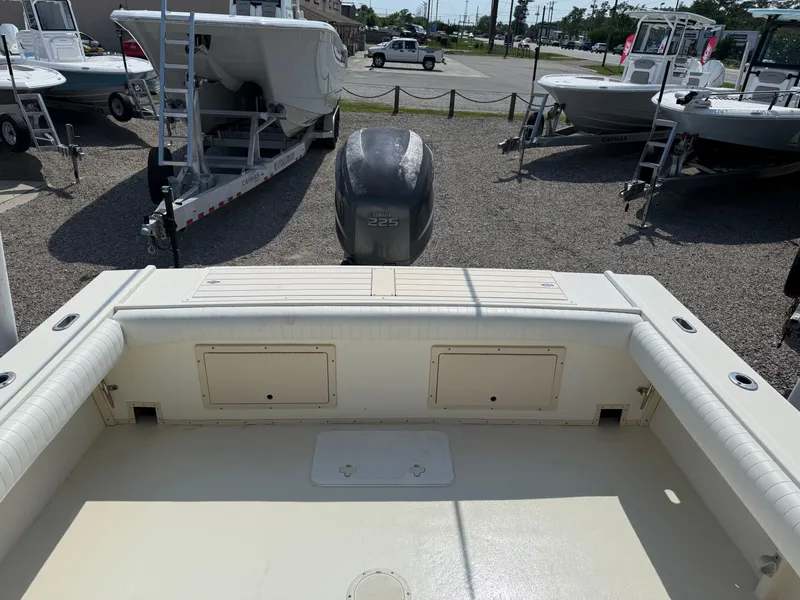 Slide: The Image of 2004 Parker 2510 Walkaround boat interior with engine view, parked on gravel. - 11