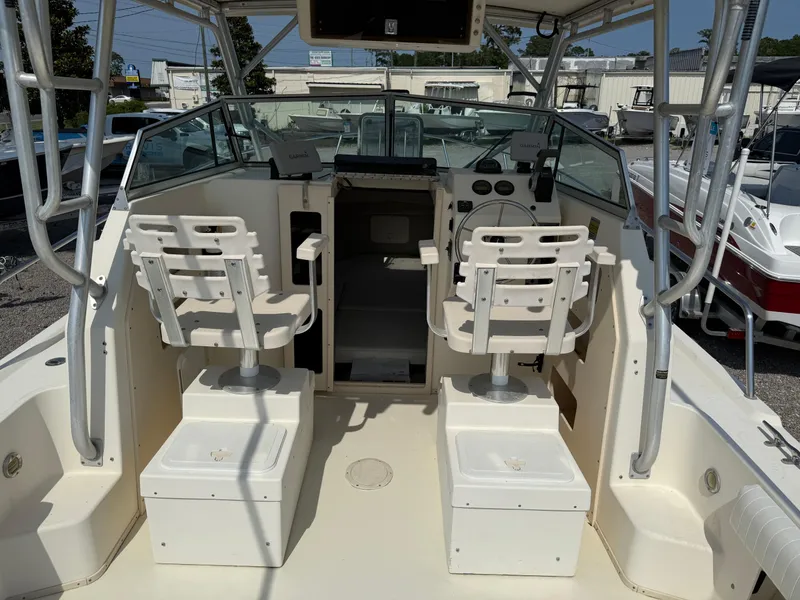 Slide: The Image of 2004 Parker 2510 Walkaround boat interior with dual captain chairs and control panel. - 15