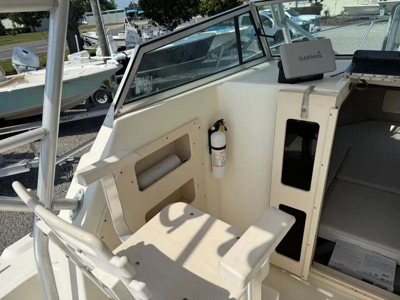 Slide: The Image of 2004 Parker 2510 Walkaround boat interior with seating, fire extinguisher, and Garmin device. - 17