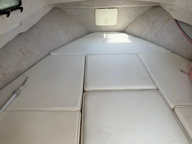 Slide: The Image of 2004 Parker 2510 Walkaround cabin interior with cushioned seating and storage hatch. - 22