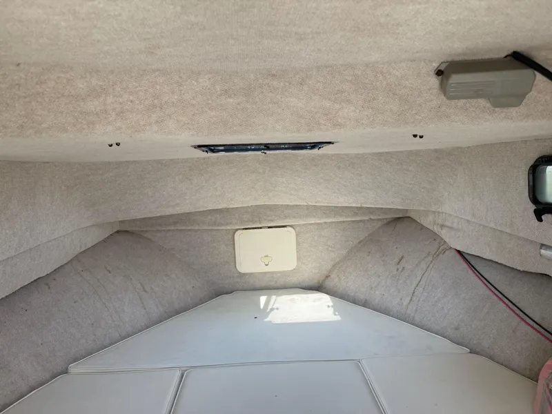 Slide: The Image of Interior cabin of a 2004 Parker 2510 Walkaround boat, featuring beige upholstery. - 23