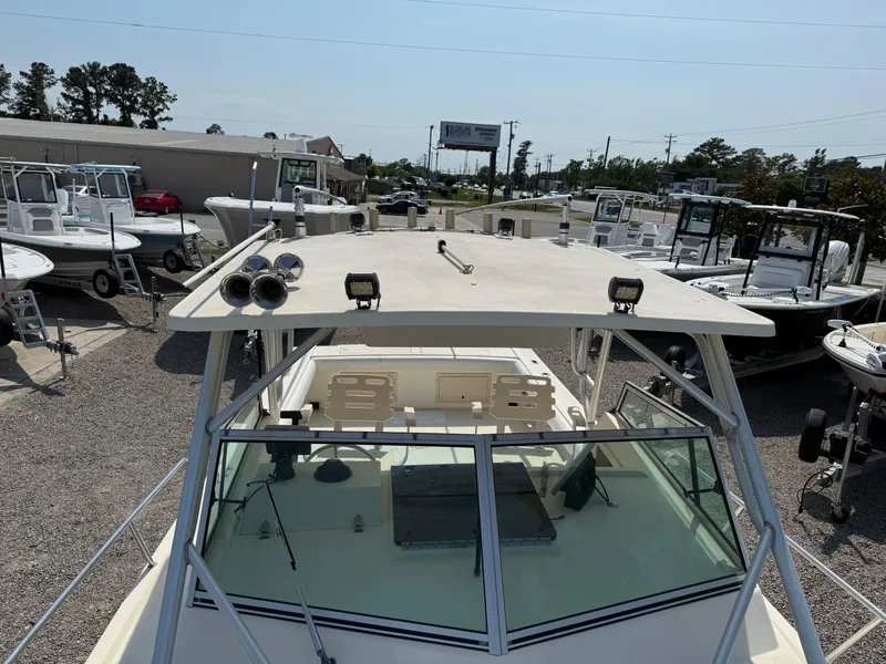 Slide: The Image of 2004 Parker 2510 Walkaround boat with rooftop view, parked in a marina. - 28