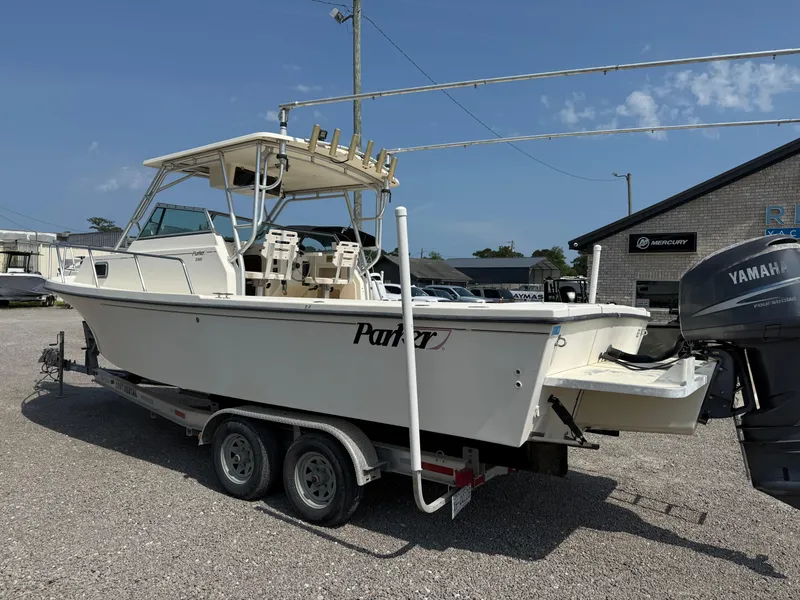 Slide: The Image of 2004 Parker 2510 Walkaround boat on trailer with Yamaha outboard motor, parked outdoors. - 3
