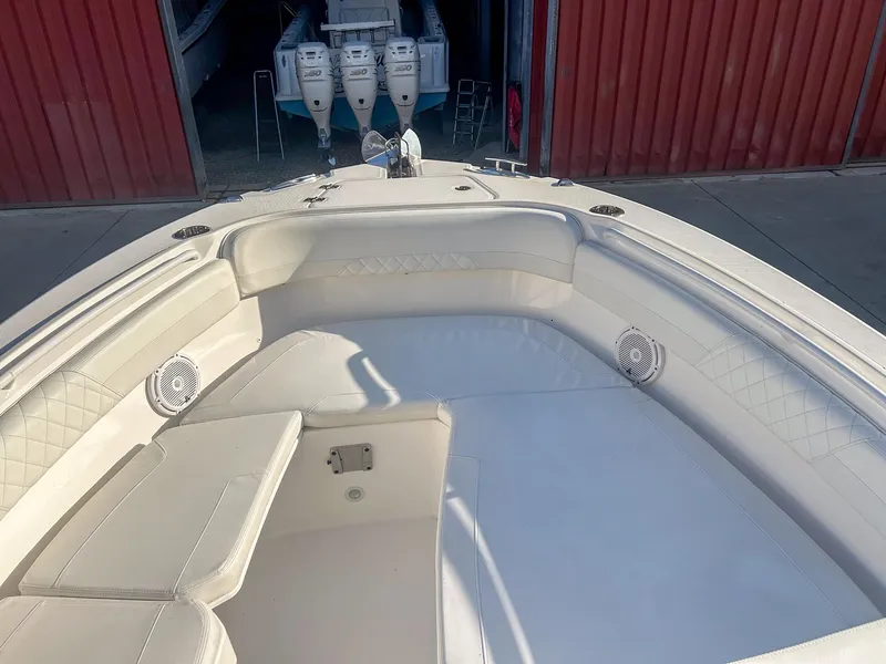 Slide: The Image of 2020 Edgewater 262 CX boat interior with white seating and visible outboard motors. - 11