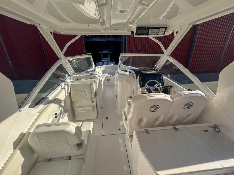 Slide: The Image of 2020 Edgewater 262 CX boat interior with white seating and modern dashboard. - 14