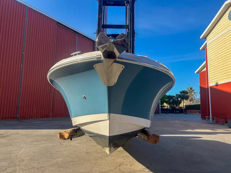 Slide: The Image of 2020 Edgewater 262 CX boat in storage, front view, blue hull, sunny day. - 4