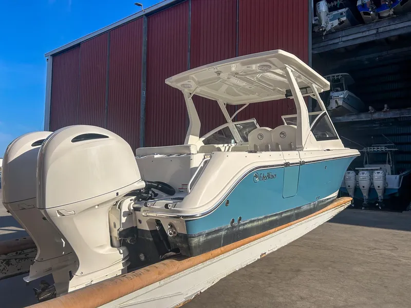 Slide: The Image of 2020 Edgewater 262 CX boat with dual engines in a marina setting. - 5