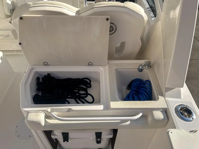 Slide: The Image of 2020 Edgewater 262 CX boat storage compartments with ropes and hose. - 8