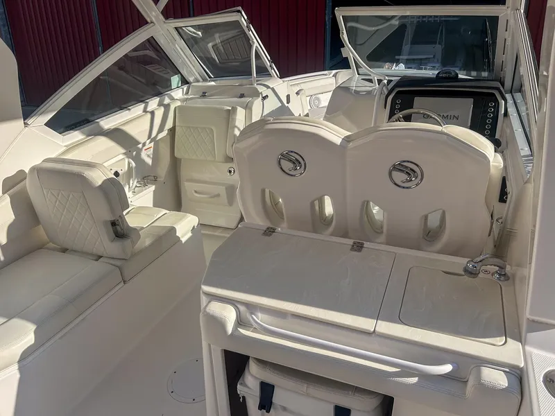Slide: The Image of 2020 Edgewater 262 CX boat interior with white seating and modern dashboard. - 9