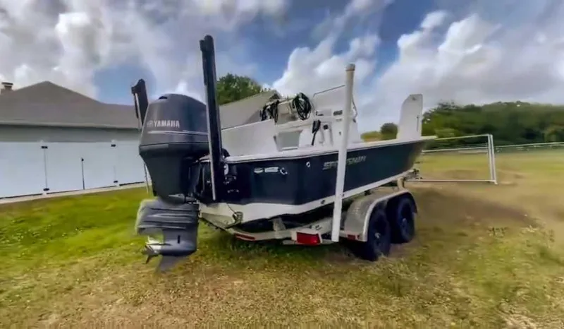 Slide: The Image of 2014 Sportsman TOURNAMENT 214 boat with Yamaha motor on trailer, parked on grass. - 3