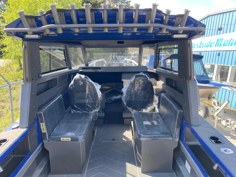 Slide: The Image of 2025 Stabicraft 2350 Supercab interior with seating and rod holders, docked at marina. - 10