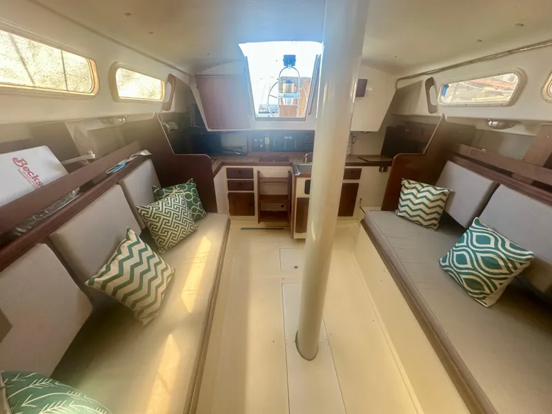 Slide: The Image of Interior of a 1979 O'Day Center Cockpit sailboat with cushioned seating and decorative pillows. - 12