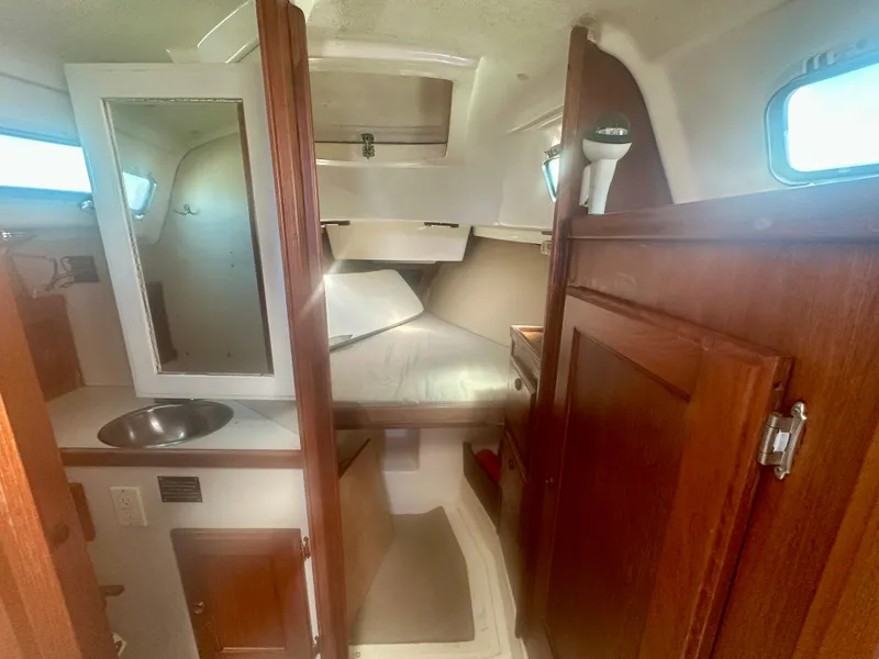 Slide: The Image of 1979 O'Day Center Cockpit interior with bed, sink, and wooden cabinetry. - 13