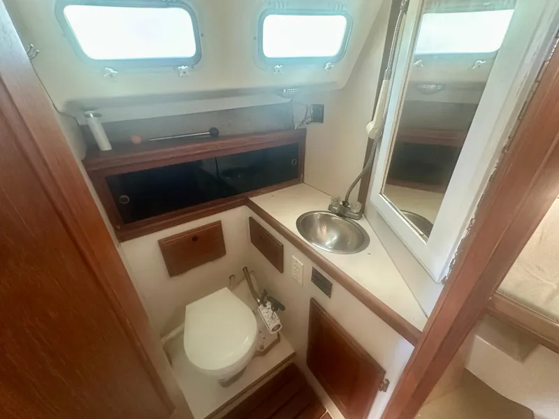 Slide: The Image of 1979 O'Day Center Cockpit bathroom with toilet, sink, and mirror. - 15