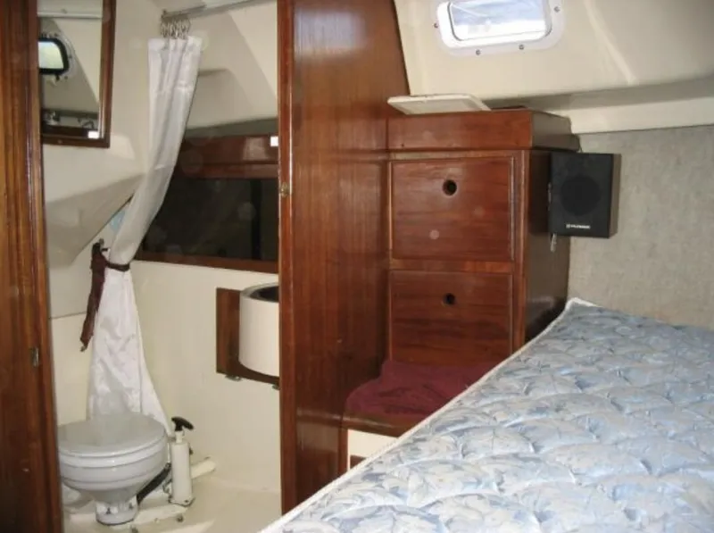 Slide: The Image of 1979 O'Day Center Cockpit interior with wooden cabinetry, bed, and compact bathroom. - 18