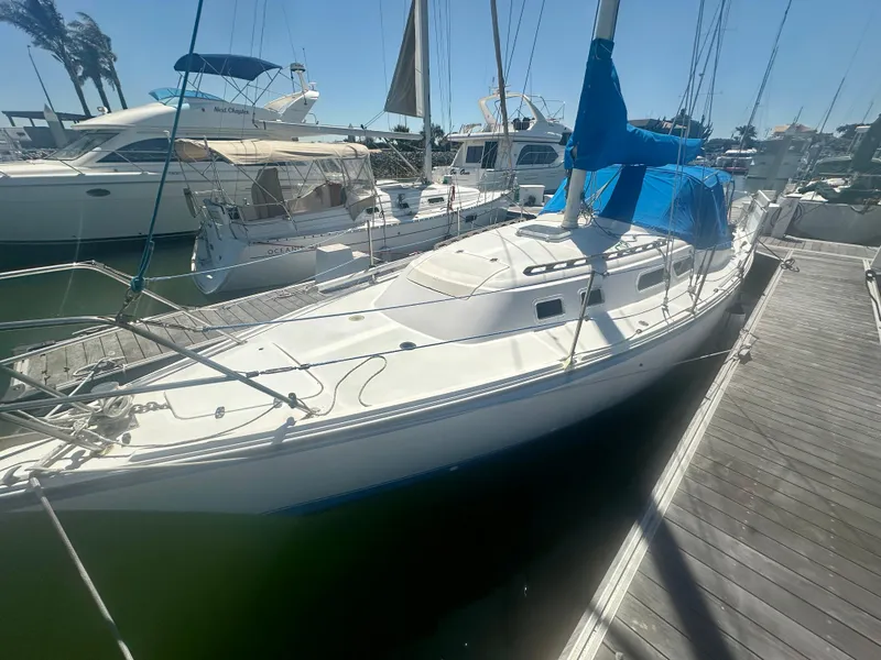 Slide: The Image of 1979 O'Day Center Cockpit sailboat docked at a marina under clear skies. - 2