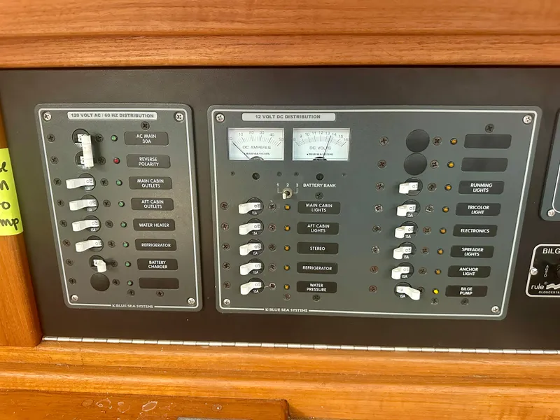 Slide: The Image of Electrical control panel of a 1979 O'Day Center Cockpit sailboat, featuring various switches and meters. - 23