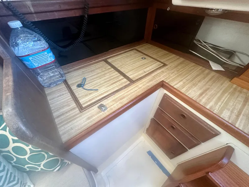 Slide: The Image of 1979 O'Day Center Cockpit interior with wooden cabinetry and countertop, featuring a water bottle and keys. - 28