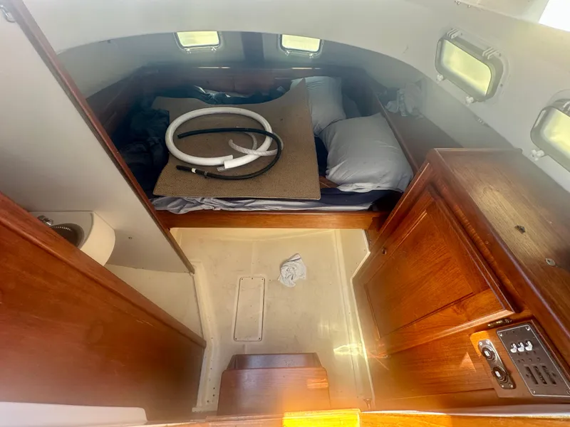 Slide: The Image of 1979 O'Day Center Cockpit interior with wooden cabinetry and cozy sleeping area. - 35