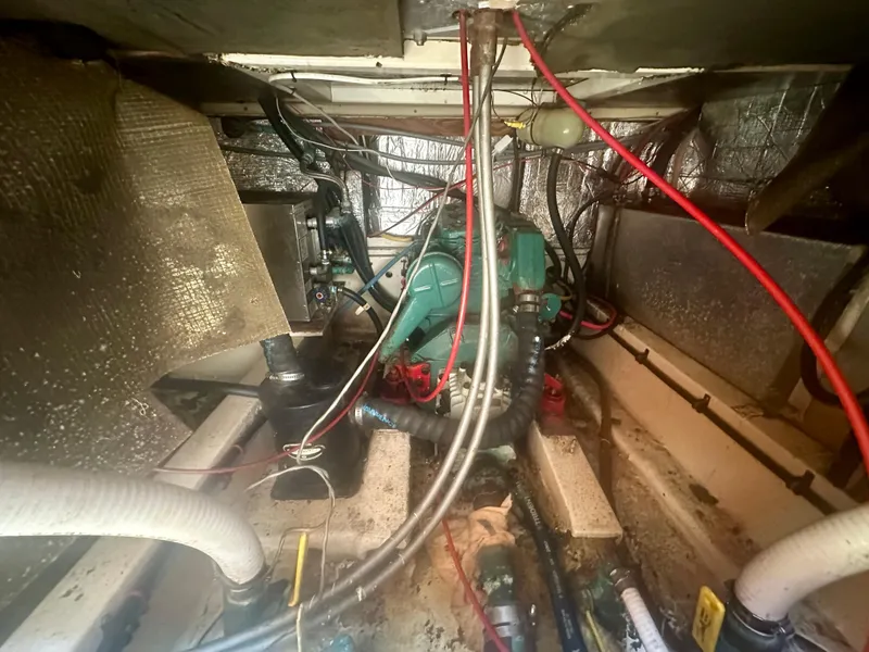 Slide: The Image of Engine compartment of a 1979 O'Day Center Cockpit sailboat, showing wiring and mechanical components. - 39