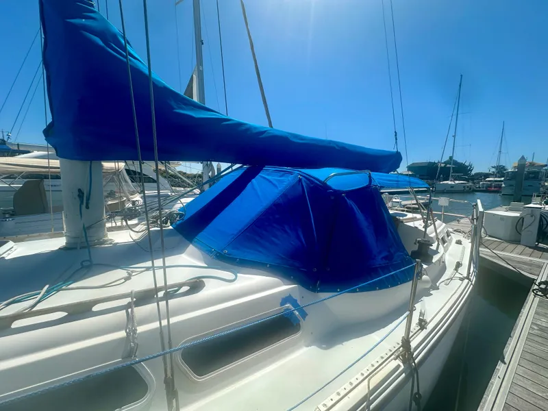 Slide: The Image of 1979 O'Day Center Cockpit sailboat with blue covers docked at a marina. - 4