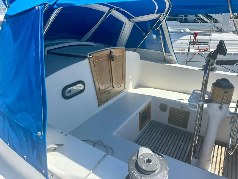 Slide: The Image of 1979 O'Day Center Cockpit sailboat with blue canopy and wooden hatch in marina. - 7