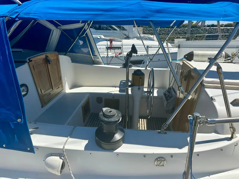 Slide: The Image of 1979 O'Day Center Cockpit sailboat with blue canopy and wooden accents in marina. - 9