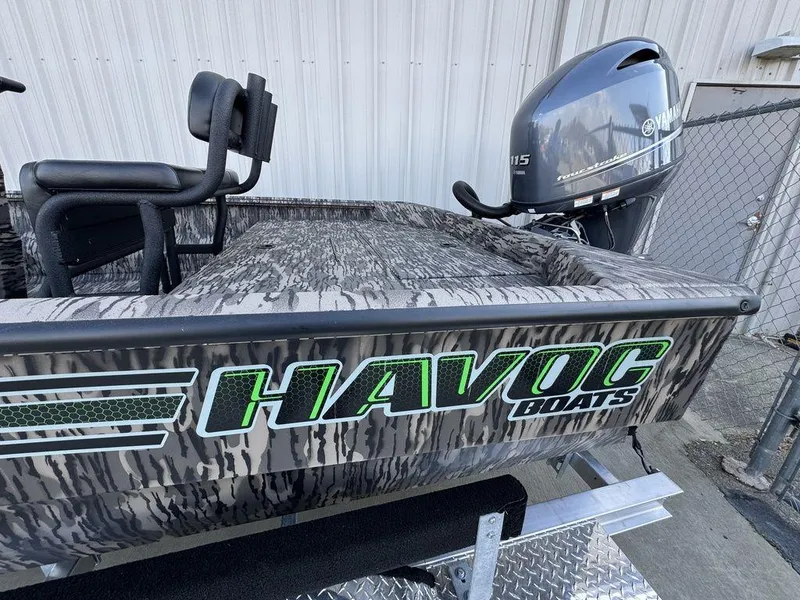 Slide: The Image of Havoc 1965 UCC boat with Yamaha motor, camo design, parked on trailer. - 16