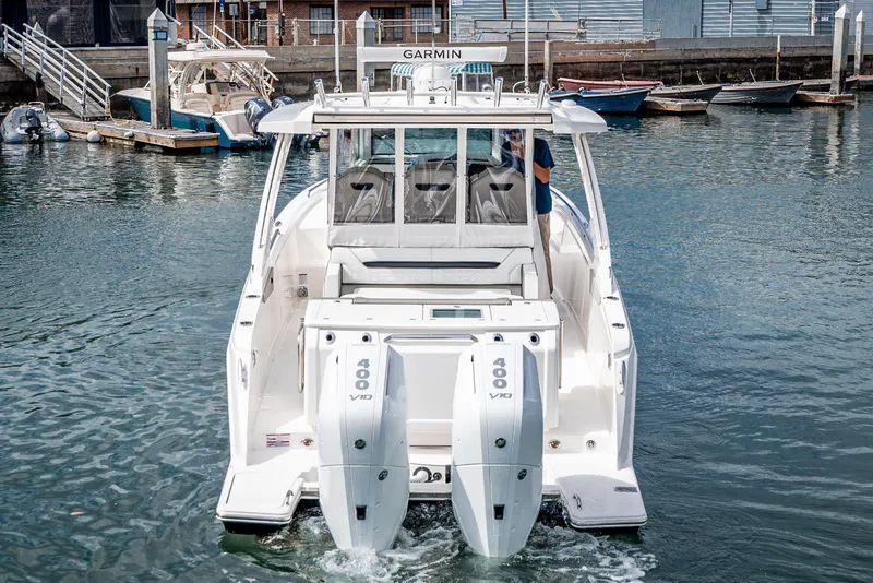 Slide: The Image of 2024 Tiara Yachts 34 LS with dual 400 engines in a marina setting. - 19