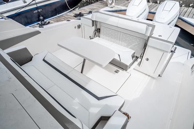 Slide: The Image of 2024 Tiara Yachts 34 LS boat interior with seating and table, docked at marina. - 22