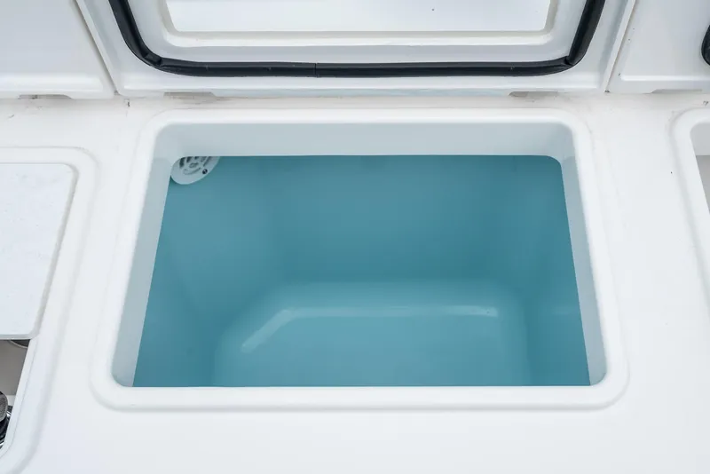 Slide: The Image of 2024 Tiara Yachts 34 LS livewell, open lid, white and blue interior. - 25