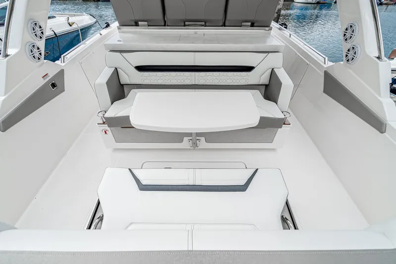 Slide: The Image of 2024 Tiara Yachts 34 LS interior with sleek seating and table, docked at marina. - 28