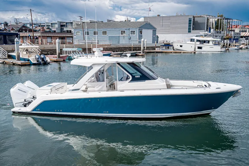 Slide: The Image of 2024 Tiara Yachts 34 LS in marina, sleek design, blue hull, modern features. - 3