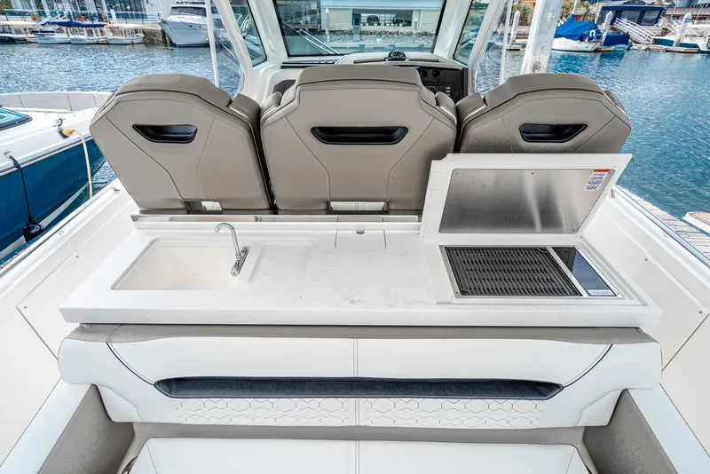 Slide: The Image of 2024 Tiara Yachts 34 LS boat interior with sink and grill at marina. - 34