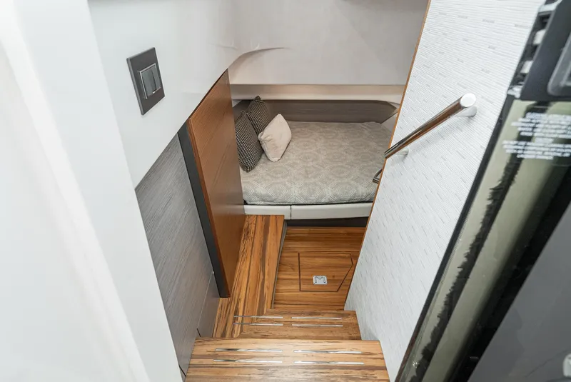 Slide: The Image of 2024 Tiara Yachts 34 LS cabin interior with wooden steps and cozy bedding. - 49