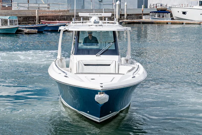 Slide: The Image of 2024 Tiara Yachts 34 LS cruising in a marina, featuring sleek design and advanced navigation. - 7