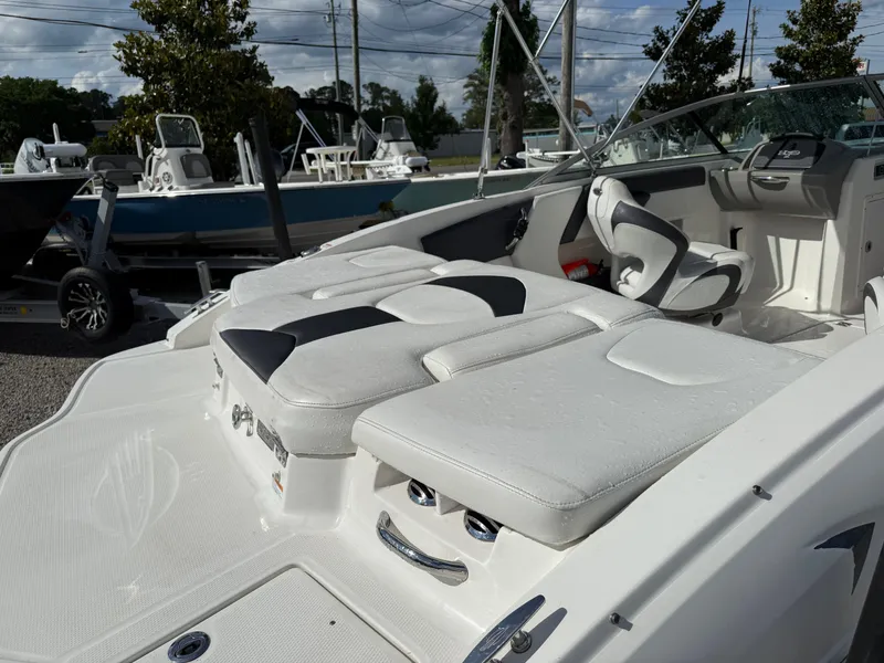 Slide: The Image of 2015 Chaparral 21 H2O Sport boat interior with white seating and steering wheel. - 10