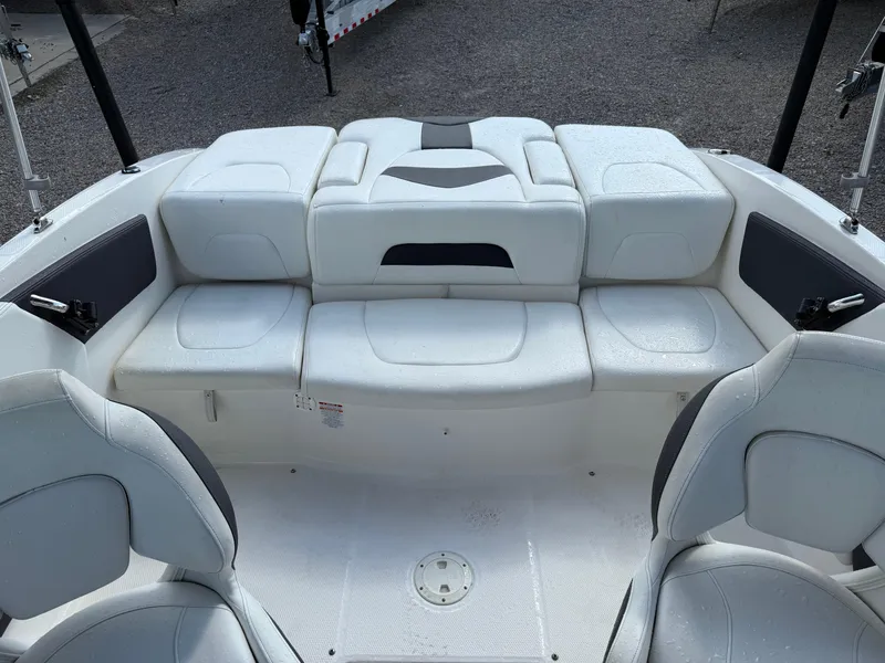 Slide: The Image of 2015 Chaparral 21 H2O Sport boat interior with white seating and storage compartments. - 17