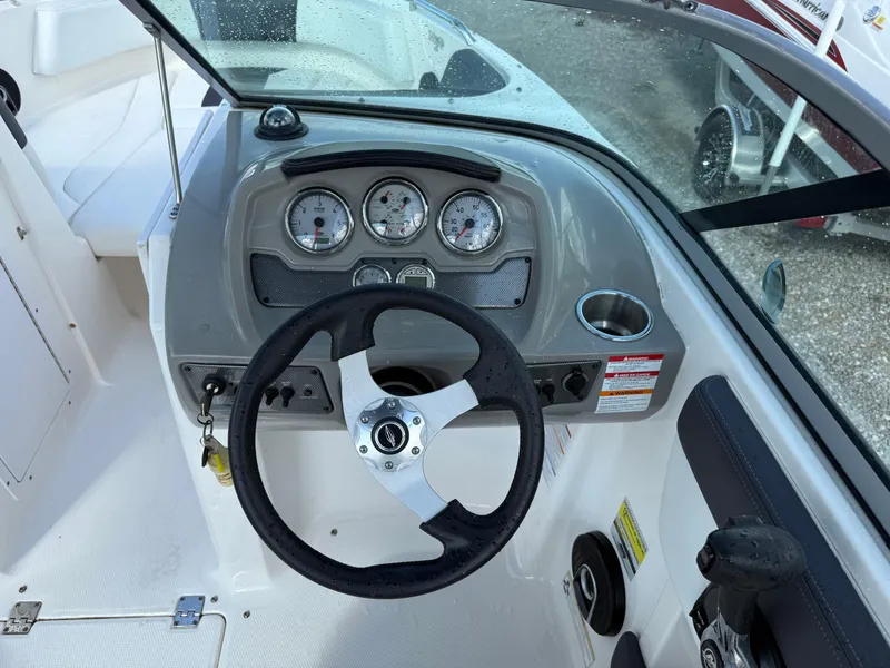 Slide: The Image of 2015 Chaparral 21 H2O Sport boat dashboard with steering wheel and gauges. - 19