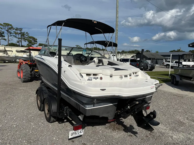 Slide: The Image of 2015 Chaparral 21 H2O Sport boat on trailer, parked outdoors under cloudy sky. - 3