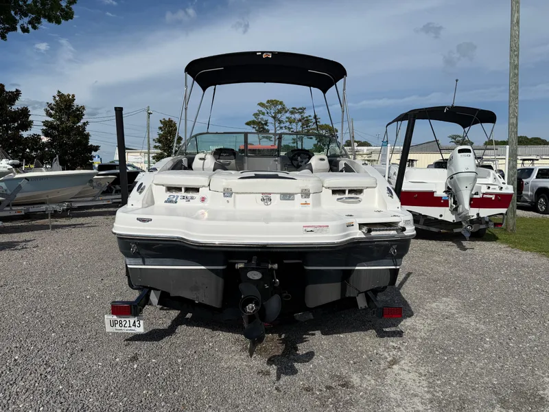 Slide: The Image of 2015 Chaparral 21 H2O Sport boat, rear view, parked on gravel lot under clear sky. - 4