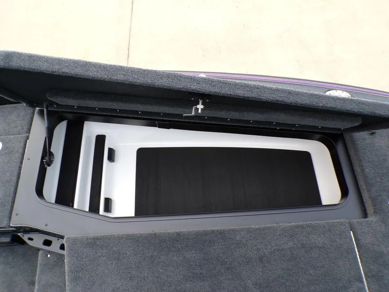 Slide: The Image of 2025 Skeeter ZXR20 boat storage compartment with carpeted interior. - 12
